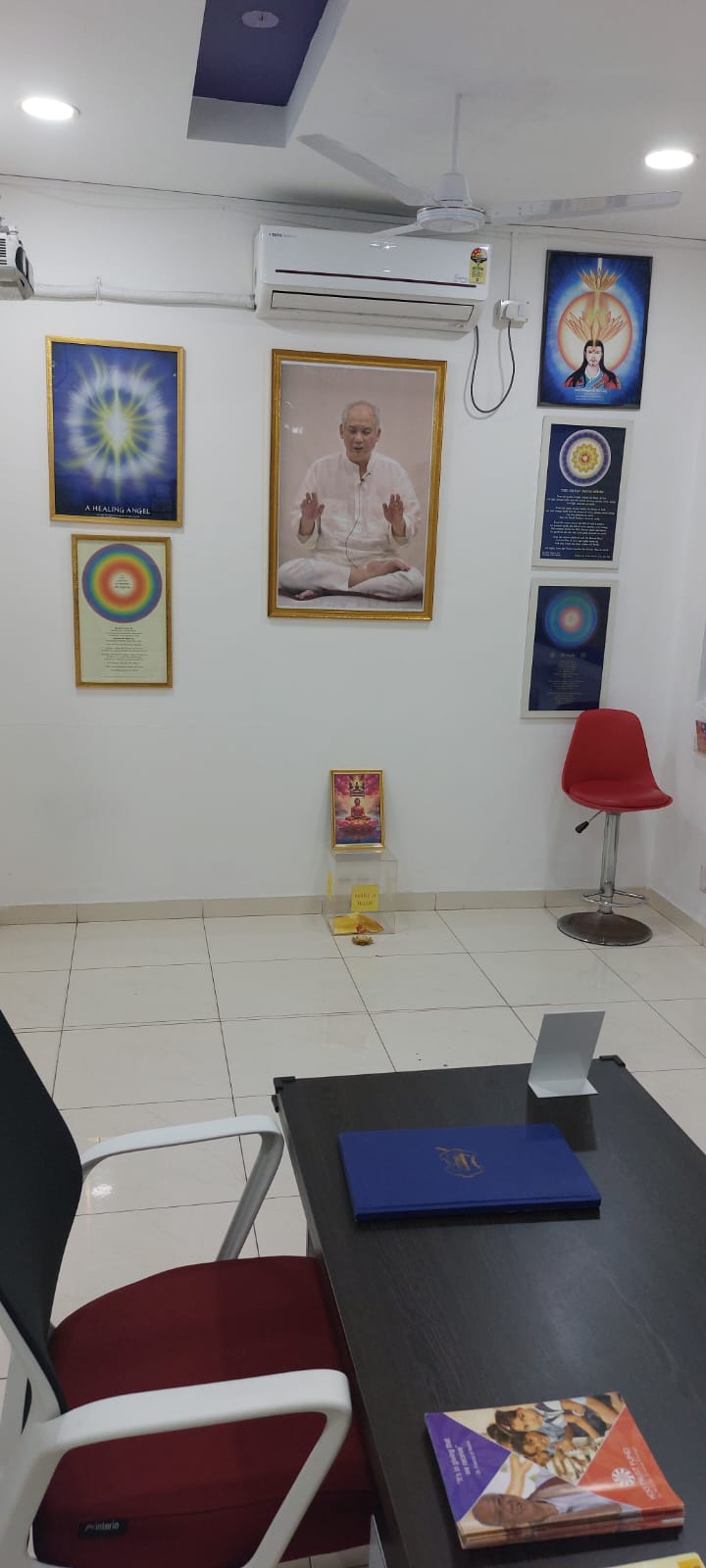 The healing room at the center: a portrait of Grand Master Choa Kok Sui and framed healing charts on the wall, with a desk and chairs